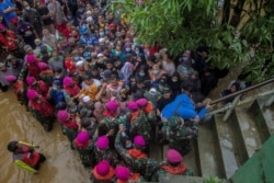 Warga terdampak banjir berkumpul untuk meminta bantuan dari Presiden RI Joko Widodo di Desa Pekauman Ulu, Kabupaten Banjar, Provinsi Kalimantan Selatan, 18 Januari 2021. (Foto: Antara/Bayu Pratama via Reuters)