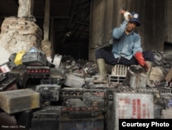 A man in Tegal, Indonesia, uses a hammer to break up old batteries by hand. Credit: LarryC. Price