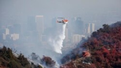 소방 헬기가 로스앤젤레스 인근에 발생한 산불을 진압하기 위해 물을 뿌리고 있다.
