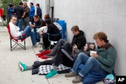 People wait in line after spending the night for the new Apple watch at Maxfield, a high-end fashion boutique in Los Angeles, April 24, 2015.