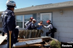 Bianna Kelsay is rescued from a building damaged by Hurricane Michael in Mexico Beach, Florida, U.S., Oct. 11, 2018.