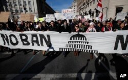 FILE - Protesters march from Lafayette Park near the White House in Washington, Feb. 4, 2017, during a rally protesting the immigration policies of President Donald Trump.