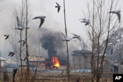 Flames and smoke billows from a residential building where militants are suspected to have taken refuge during a gun battle in Pulwama, south of Srinagar, Indian controlled Kashmir, Monday, Feb. 18, 2019.