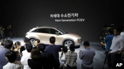 Hyundai Motor Co.'s new hydrogen fuel cell vehicle is surrounded by members of media during a media preview in Seoul, South Korea, Thursday, Aug. 17, 2017. (AP Photo/Lee Jin-man)