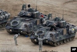 A U.S. Army soldier gestures to a fellow solider as they participate in annual military drills in Yeoncheon, South Korea, near the border with North Korea, April 11, 2013.