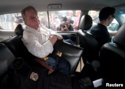 Antonio Celso Grecco, the owner of Rodrimar, a company which operates some services in the port of Santos, is escorted by a federal police officer at the federal police headquarters in Sao Paulo, Brazil, March 29, 2018.