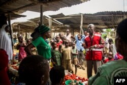 A Red Cross volunteer explains measures to prevent infection with Ebola to inhabitants, on Aug. 17, 2018 in Butugo, western Uganda, near the border with Democratic Republic of Congo.