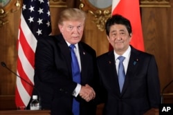 President Donald Trump, left, shakes hands with Japanese Prime Minister Shinzo Abe during a joint news conference at the Akasaka Palace, Monday, Nov. 6, 2017, in Tokyo.