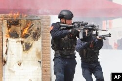 FILE - Crew members of the Taiwan Coast Guard aim their weapons during an offshore anti-terrorism drill outside Keelung harbor in New Taipei City, Taiwan.