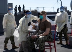 FILE - A United States Navy officer from the USS San Diego receives a vaccine against coronavirus at the navy port in Manama, Bahrain in this picture taken February 26, 2021 and released by U.S Navy on February 27, 2021. (Brandon Woods/U.S. Navy/Handout via REUTERS)