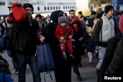 Refugees and migrants arrive aboard the Blue Star 1 passenger ship from the islands of Lesbos and Chios at the port of Piraeus, near Athens, Greece, Feb. 23, 2016.
