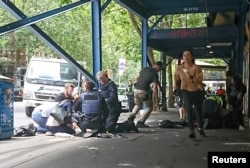 Members of the public watch as police and emergency services attend to an injured person after a car hit pedestrians in central Melbourne, Australia, Jan. 20, 2017.