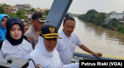 Gubernur Jawa Timur Khofifah didampingi Direktur Eksekutif Ecoton Prigi Arisandi melihat langsung kondisi jembatan yang dijadikan tempat membuang sampah popok oleh warga (foto Petrus Riski-VOA)