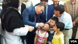 والی ولایت فاریاب حین انداختن قطرات واکسین در دهن اطفال