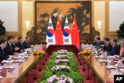 South Korean President Moon Jae-in, second right, and Chinese President Xi Jinping, second left, are seen with other officials during a bilateral meeting at the Great Hall of the People in Beijing, China, Dec. 14, 2017.