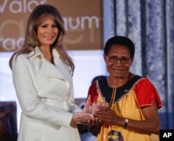 FILE - First lady Melania Trump presents the 2017 Secretary's of State's International Women of Courage (IWOC) Award to Veronica Simogun from Papua New Guinea, March 29, 2017, at the State Department in Washington.