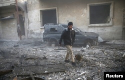 A man inspects the damage at a site hit by airstrikes in the rebel held besieged Douma neighborhood of Damascus, Syria, Feb. 19, 2017.
