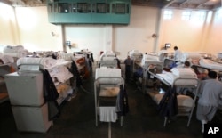 FILE - In this Jan. 14, 2009 file photo, triple-tier bunks are seen in a gymnasium converted to house prisoners at the California Substance Abuse Treatment Facility and State Prison in Corcoran, Calif.
