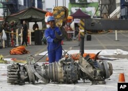Para petugas memindahkan mesin Lion Air JT610 untuk penyelidikan di Jakarta, 4 November 2018.