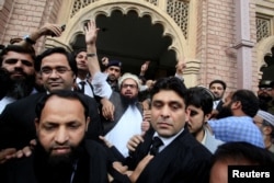 Hafiz Saeed (C) reacts to supporters as he walks out of court after a Pakistani court ordered his release from house arrest in Lahore, Pakistan, Nov. 22, 2017.