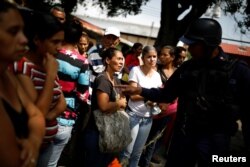 Relatives of inmates talk to a police officer as they wait for information after a riot and a fire in the cells of the General Command of the Carabobo Police in Valencia, Venezuela, March 29, 2018.