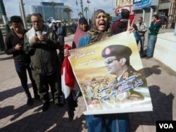 An Egyptian woman holds a poster for the Egyptian president which reads in Arabic: "Happy anniversary, Sisi" in Tahrir Square, Cairo, Egypt. Monday Jan 25, 2016. (VOA Photo/Hamada Elrasam)