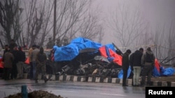 Forensic officials inspect the wreckage of a bus after a suicide bomber rammed a car into the bus carrying Central Reserve Police Force (CRPF) personnel Thursday, in Lethpora in south Kashmir's Pulwama district, Feb. 15, 2019.