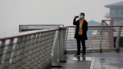 A man takes a photo at an overlook in Wuhan, in central China's Hubei Province, Jan. 22, 2022.