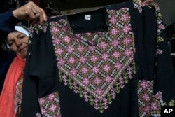 Samiha Jeheshat, memamerkan gaun thobe Palestina dengan sulaman tangan di ruang pamernya di Desa Idna, Tepi Barat, utara Hebron, 28 Januari 2019.