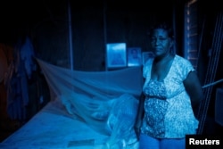 Milagros Jimenez poses for a picture at her house, which was partially destroyed by Hurricane Maria, at the squatter community of Villa Hugo in Canovanas, Puerto Rico, Dec. 9, 2017.