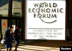 FILE - An attendee arrives in the Congress Hall during the World Economic Forum annual meeting in Davos, Switzerland Jan. 20, 2017.