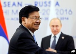 FILE - Russian President Vladimir Putin meets with Laos' Prime Minister Thongloun Sisoulith on the sidelines of the ASEAN - Russia summit in the Black Sea resort of Sochi, Russia, May 19, 2016.