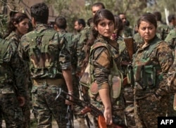 Borci Sirijskih demokratskih snaga (SDF), koje podržava Amerika, uključujući i žene, okupljaju se na proslavi u blizini naftnog polja u Omaru u istočnoj sirijskoj pokrajini Deir Ezor, 23. marta 2019, nakon proglašenja totalne eliminacije samoproklamovanog kalifata Islamske države.