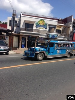 A jeepney drives through Barrio Barretto, Oct. 22, 2015. (R. Jennings/VOA)