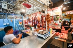 A vendor waits for customers at a market in Managua, Nicaragua, Dec. 21, 2018. In the streets of Managua, outward appearances suggest some degree of normality. But vendors say business has been running 25 to 30 percent below what it was last year, even in the run-up to Christmas.