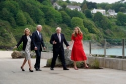 President Joe Biden and first lady Jill Biden are greeted and walk with British Prime Minister Boris Johnson and his wife Carrie Johnson, ahead of the G-7 summit, Thursday, June 10, 2021, in Carbis Bay, England. (AP Photo/Patrick Semansky)