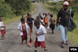 Fransiskus Kasipmabin dan anak-anak sekolah di Pegunungan Bintang, Papua. (Foto: VOA/Nurhadi).