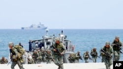 FILE - In this May 9, 2018 photo, Philippine and U.S. Marines storm a beach as part of an amphibious landing exercise during a two-week joint U.S.-Philippines exercise facing the South China Sea in the Philippines.
