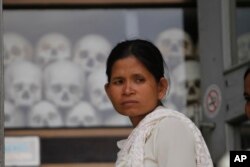 ស្ត្រី​ម្នាក់ឈរ​នៅ​មុខ​ចេត្តិយ​ដែល​ត​ម្កល់​លលាដ៍និង​ឆ្អឹងរបស់​ជន​រង​គ្រោះ​ក្នុង​របបខ្មែរ​ក្រហមនៅ​សារមន្ទីរ​ជើង​ឯក​នៅ​ជាយ​រាជធានី​ភ្នំពេញ កាល​ពី​ថ្ងៃ​សុក្រ​ទី​១៧ ខែ​មេសា ឆ្នាំ​២០១៥។ លោក សម រង្ស៊ី ប្រធាន​គណបក្ស​សង្គ្រោះ​ជាតិ​កាល​ពី​ថ្ងៃ​សុក្រ​បាន​ដឹកនាំ​ពិធី​បុណ្យបែបព្រះ​ពុទ្ធសាសនា​មួយ​ដើម្បី​រំឭក​ខួប​ទី​៤០​នៃ​ការ​ធ្លាក់​របស់​ទី​ក្រុង​ភ្នំពេញ​ចូល​ក្នុង​ការកាន់កាប់​របស់​ទាហាន​ខ្មែរក្រហម។ (AP Photo/Heng Sinith)