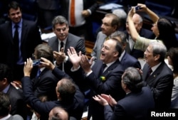 Members of Brazil's Senate react after a vote to impeach President Dilma Rousseff for breaking budget laws in Brasilia, Brazil, May 12, 2016.