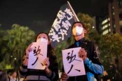 Protesters hold placards baring the words "Release People", as they gather near the Polytechnic University in Hong Kong, Monday, Nov. 25, 2019.