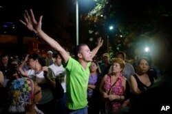 FILE - An opposition supporter celebrates the closing of a polling station during congressional elections in Caracas, Venezuela, Dec. 6, 2015.