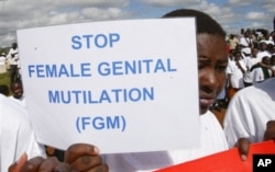 FILE - Masai girl holds protest sign during anti-Female Genital Mutilation (FGM) run in Kilgoris, Kenya