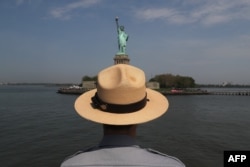 FILE - A U.S. park ranger looks towards the Statue of Liberty while in route to Ellis Island.