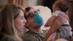 Emergency medicine physician Thomas Krajewski hold his baby Cal.