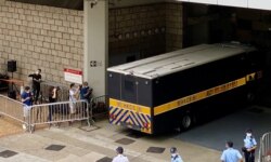 有声援唐英杰的市民质疑当局安排多部囚车出入高等法院，企图误导支持者，不能送别押解唐英杰到监狱的囚车（美国之音/汤惠芸）