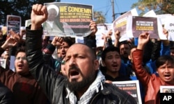 FILE - Muslims students carry placards and shout slogans against the Nigerian government after the killings of hundreds of Shi'ite Muslims and the detaining of their leader Ibraheem Zakzaky in Nigeria, in Jammu, India, Dec. 15, 2015.