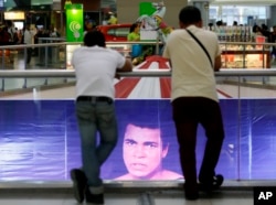 Filipino fans look at the memorabilia of the Oct. 1, 1975 "Thrilla in Manila" World Heavyweight boxing fight between Muhammad Ali and Joe Frazier at the launch of an exhibit at The Ali Mall in suburban Quezon city northeast of Manila, Philippines Friday, June 10, 2016.