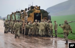 Turkish Army soldiers form a convoy of armoured personnel carriers near the border with Syria, in the outskirts of Hassa, Turkey, Jan. 23, 2018.