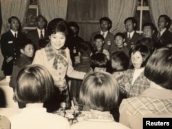 FILE - Park Geun-hye greets children when she served as her father and then-President Park Chung-hee's first lady in the 1970s, after her mother Yuk Young-soo was assassinated by a North Korean-backed gunman.